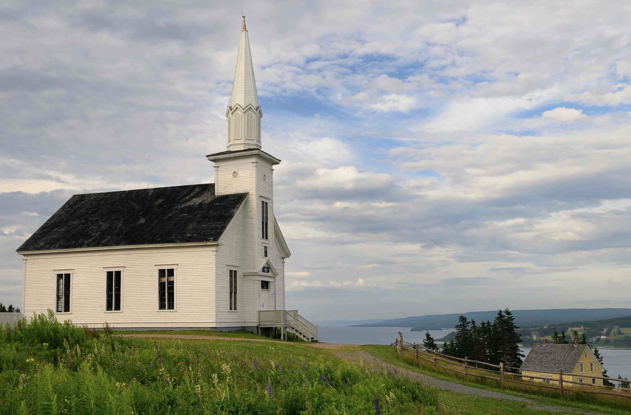 Historic church at Highland Village Museum Iona Cape Breton with Great Bras dOr Lake Reimar shutterstock_1312184348